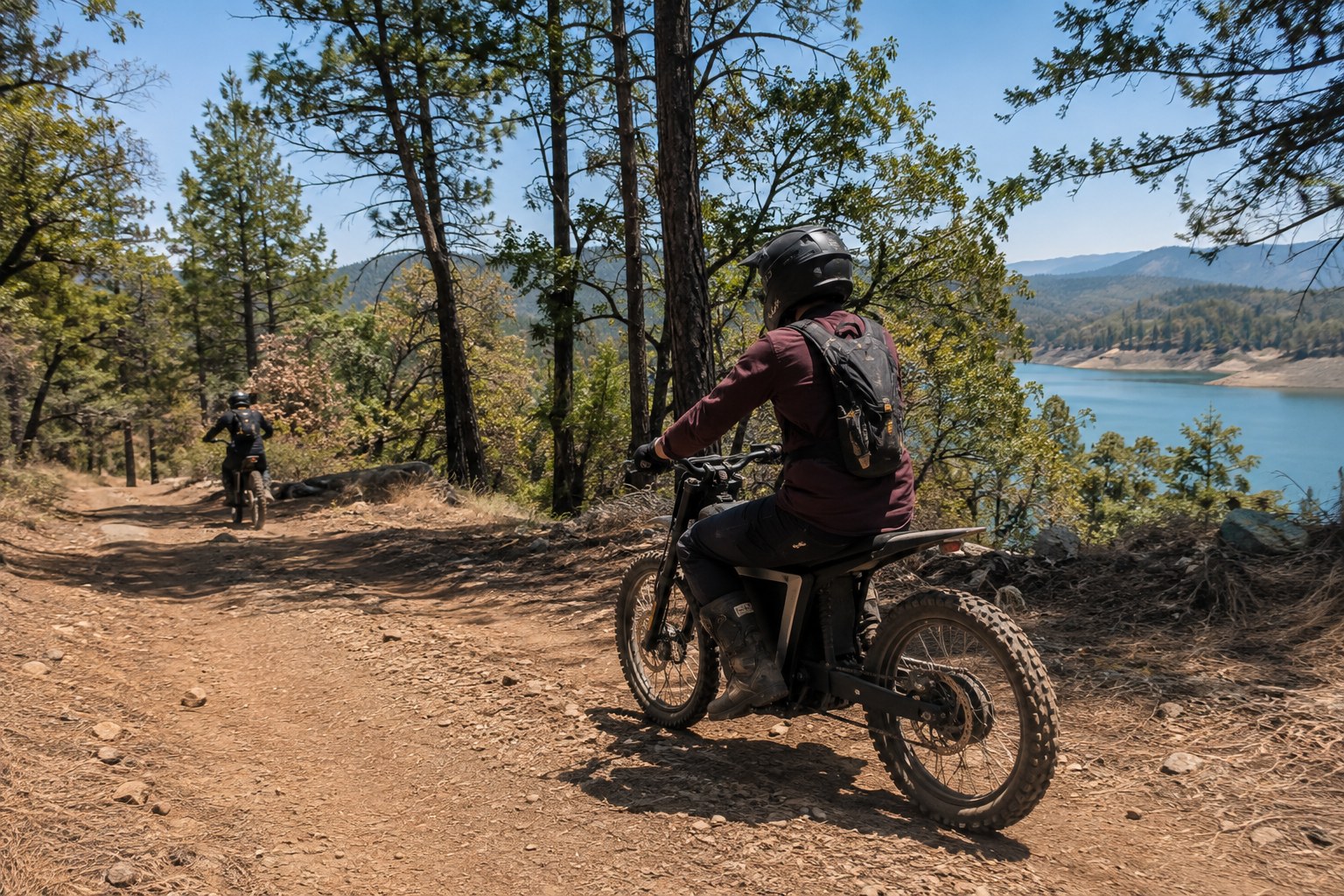 Two electric dirtbike riders exploring a pine trail above Lake Shasta