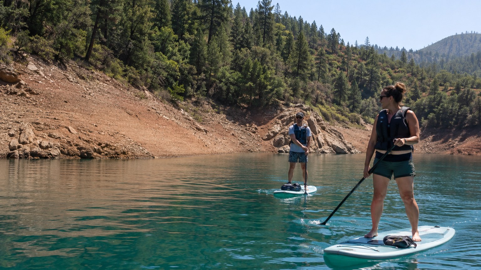 Guests paddleboarding in a quiet Lake Shasta cove