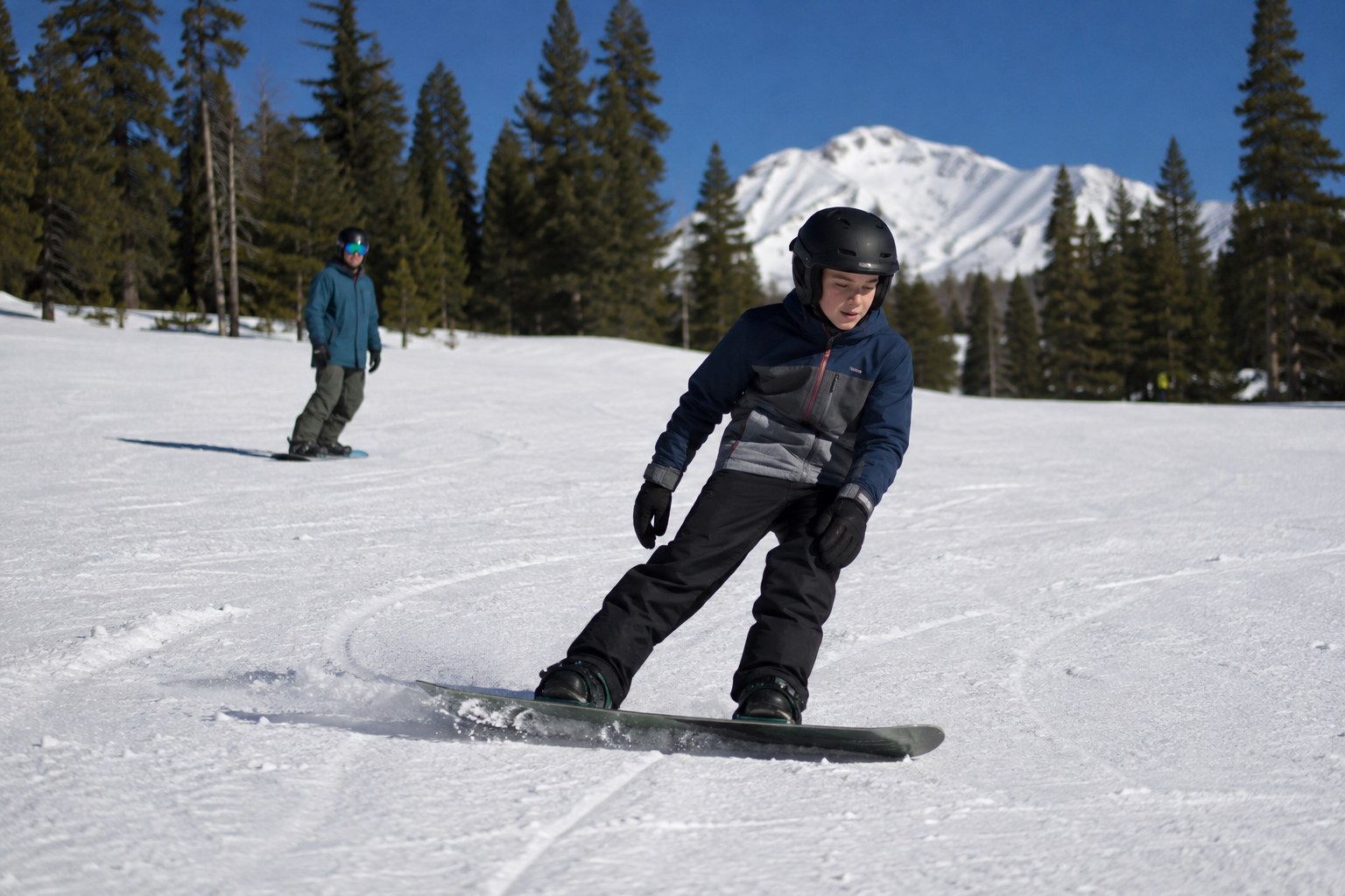A student making a controlled snowboard turn
